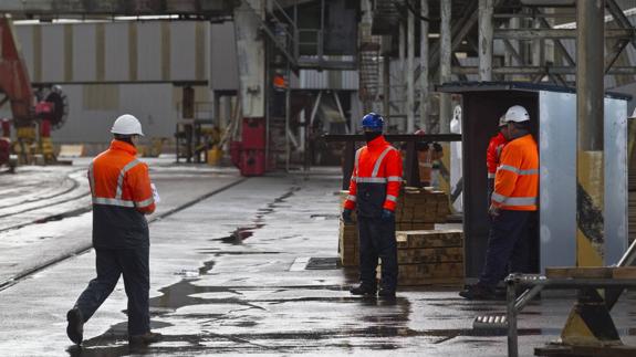 Estibadores portuarios realizan labores de carga en el puerto de Santander.