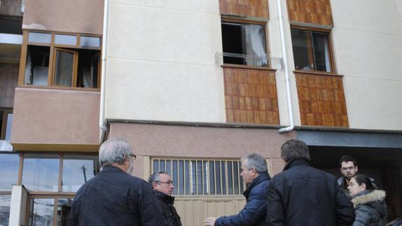 Varios vecinos, charlan frente a la vivienda afectada.