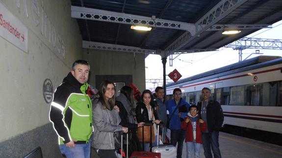 David Aja, director de Alto Campoo, a la izquierda, junto a los primeros pasajeros del ‘tren blanco’, en la estación de Reinosa.