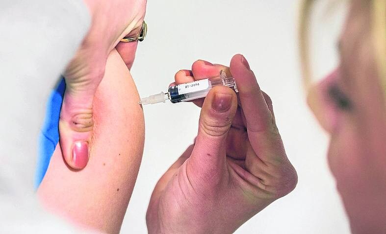 Una sanitaria pone la vacuna del sarampión 