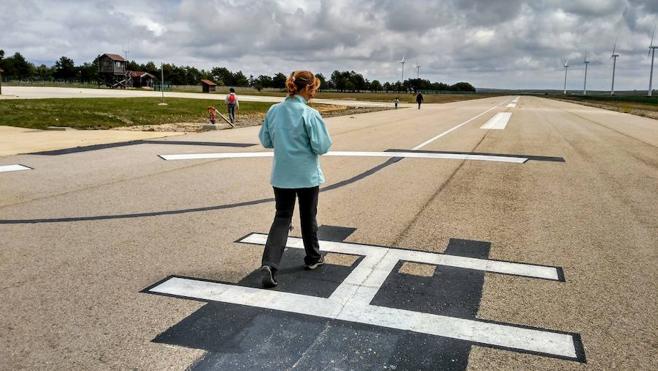 La pista de aterrizaje del aeródromo de La Lora, reconvertida en helipuerto, con sus instalaciones a la izquierda y los molinos de viento burgaleses a la derecha.