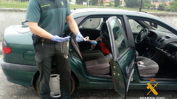 Un agente recoge joyas y otros objetos robados que ocultaban en su coche.