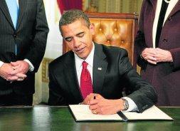 Barack Obama firma en el Capitolio su primer documento como presidente de EE UU. / AP