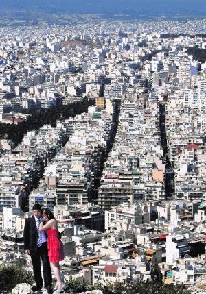 Una pareja en el  monte Licabeto,  con Atenas al  fondo.  ::                                                        JOHN KOLESIDIS/REUTERS