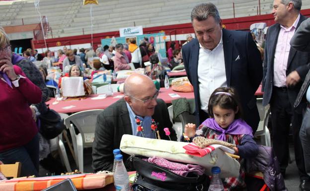 Jesús Julio Carnero se interesó por la labor que tejía la niña de menor edad participante en el encuentro de Arroyo en presencia del alcalde, José Manuel Barrio. 