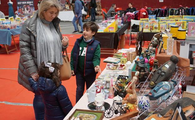 Una mujer visita uno de los puestos de El Mercado de Arroyo junto con sus dos hijos. 