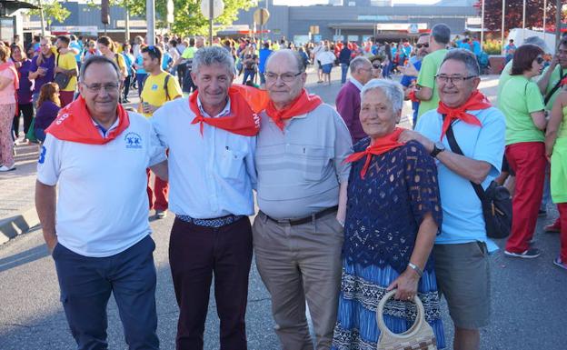 Sarbelio Fernández arropado por unos vecinos durante el desfile de peñas de inicio de las fiestas patronales de La Flecha. 