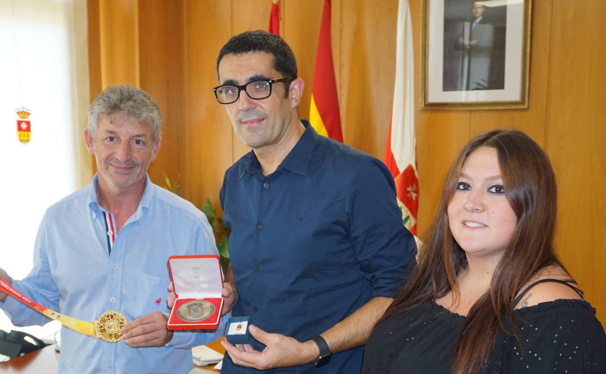 El alcalde, Sarbelio Fernández, sonriente con la medalla de oro de Pekín que Javi Bello llevó al ayuntamiento de Arroyo, en presencia de la concejala de Deportes, Ana Sánchez. 