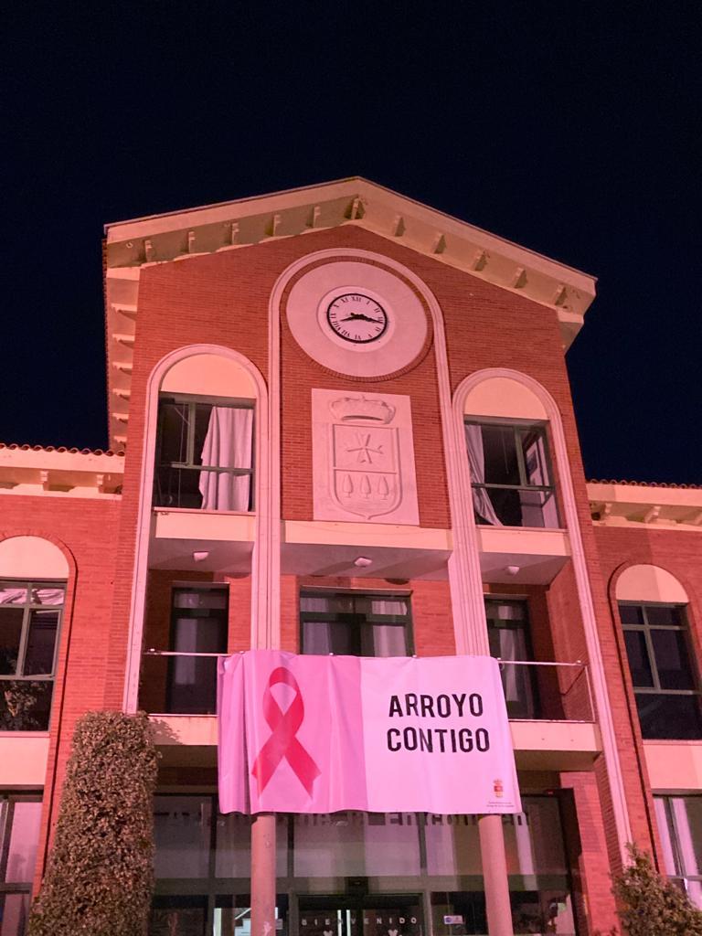 Pórtico de entrada a la iglesia de Arroyo iluminada en rosa. 