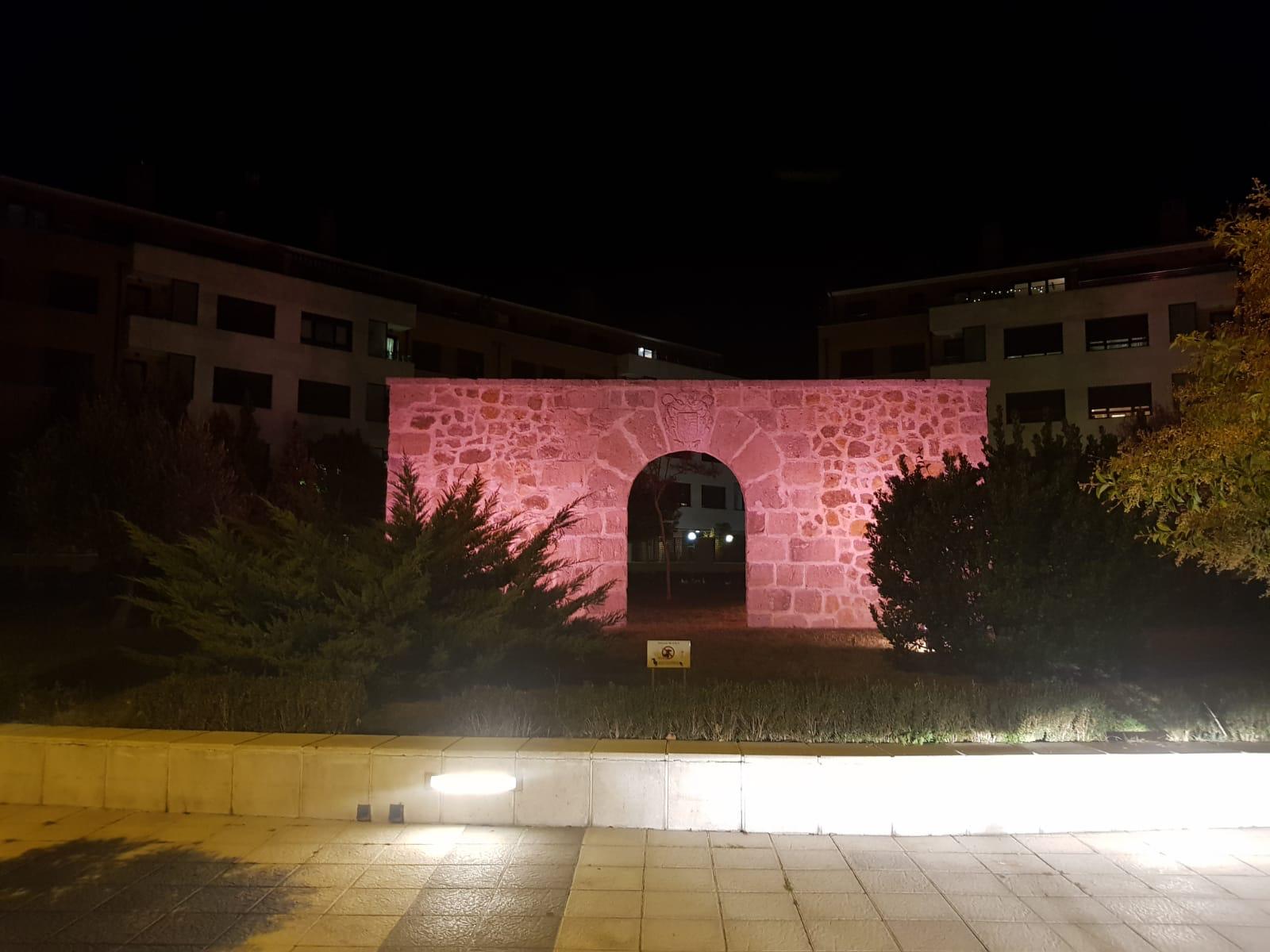 Pórtico de entrada a la iglesia de Arroyo iluminada en rosa. 