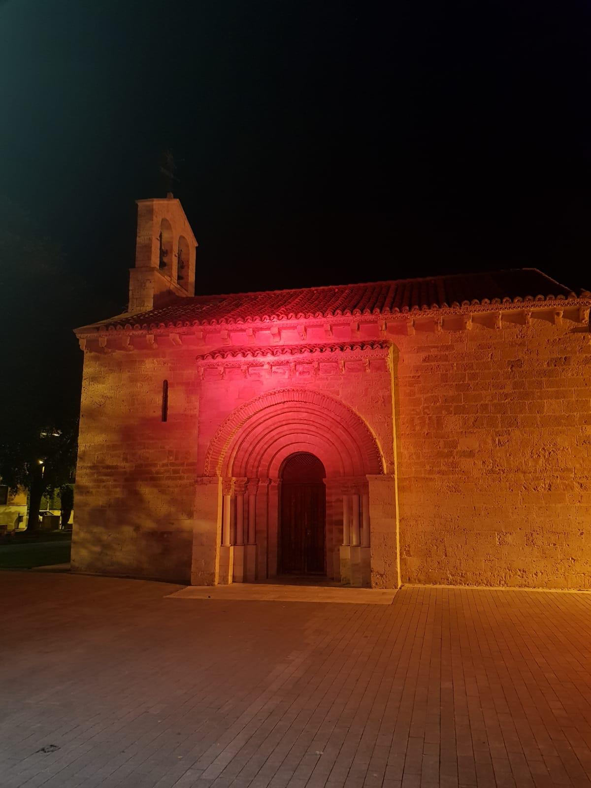 Pórtico de entrada a la iglesia de Arroyo iluminada en rosa. 