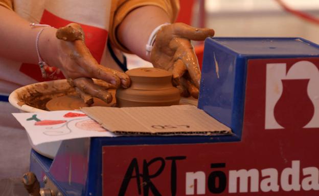 Detalle de uno de los niños participantes modelando el barro. 