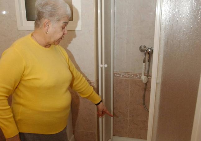 Una mujer muestra su nuevo plato de ducha