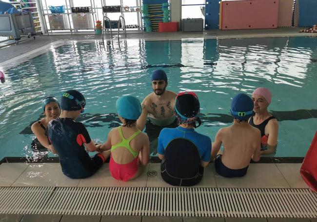 Niños del CEIP Kantic@ participando en el programa 'Inclúyete a natación', con su profesora, su ATE y el monito del CDO La Almendrera