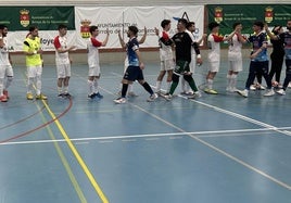 Los dos equipos saludándose tras el encuentro en el polideportivo Antonio Garnacho