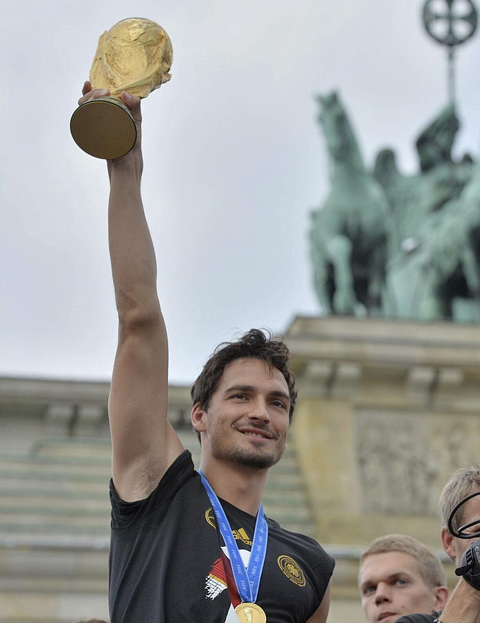 LA SELECCIÓN ALEMANA CELEBRA LA COPA DEL MUNDO CON MILES DE AFICIONADOS. El alemán Mats Hummels alza la Copa del Mundo frente a los cientos de miles de aficionados que recibieron al combinado alemán en la Puerta de Brandeburgo en Berlín.