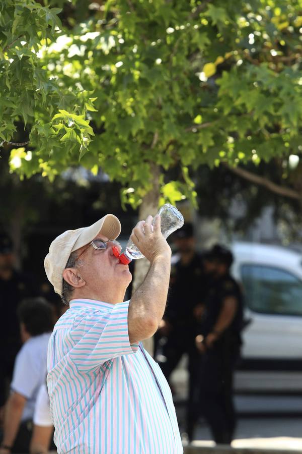 Un hombre bebe agua en la sombra frente al Congreso de los Diputados en Madrid, en una jornada con temperaturas de hasta 38 grados en plena ola de calor.