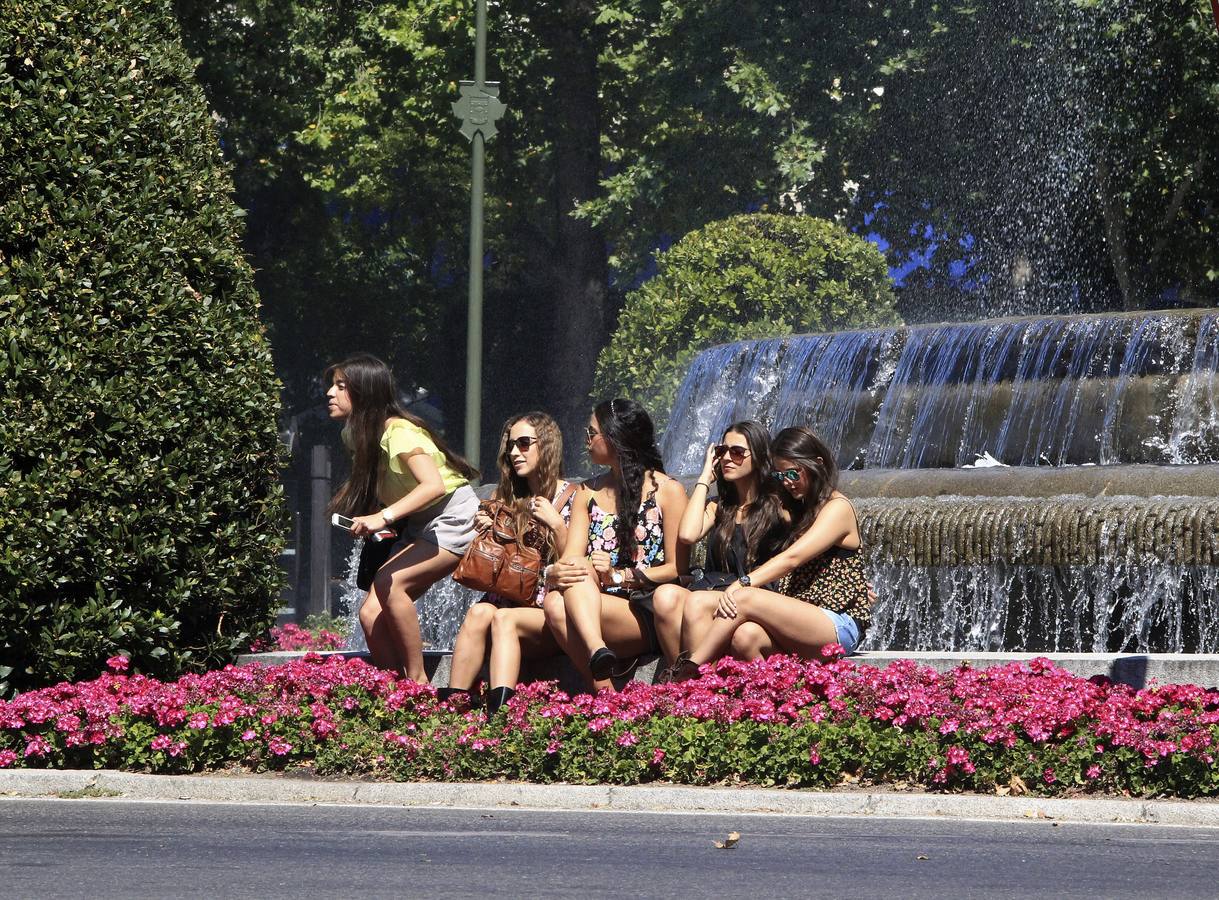 Varias chicas se refrescan frente a la fuente de Neptuno de Madrid, en una jornada con temperaturas de hasta 38 grados en plena ola de calor .