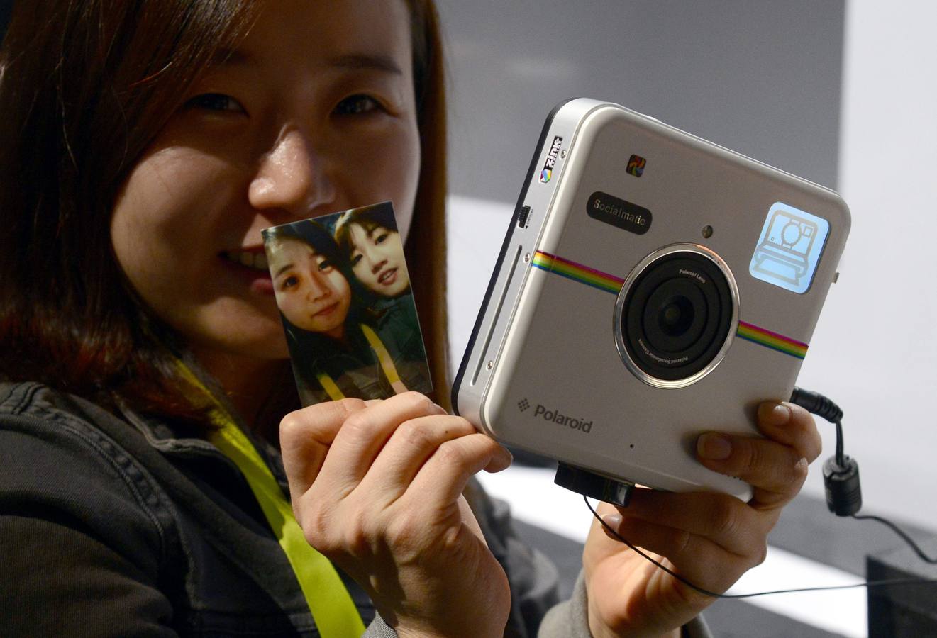 Una mujer muestra una impresión de la cámara instantánea Polaroid Socialmatic.