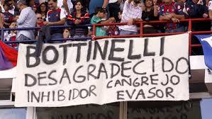 Pancarta contra el futbolista Jonathan Bottinelli en un estadio argentino.