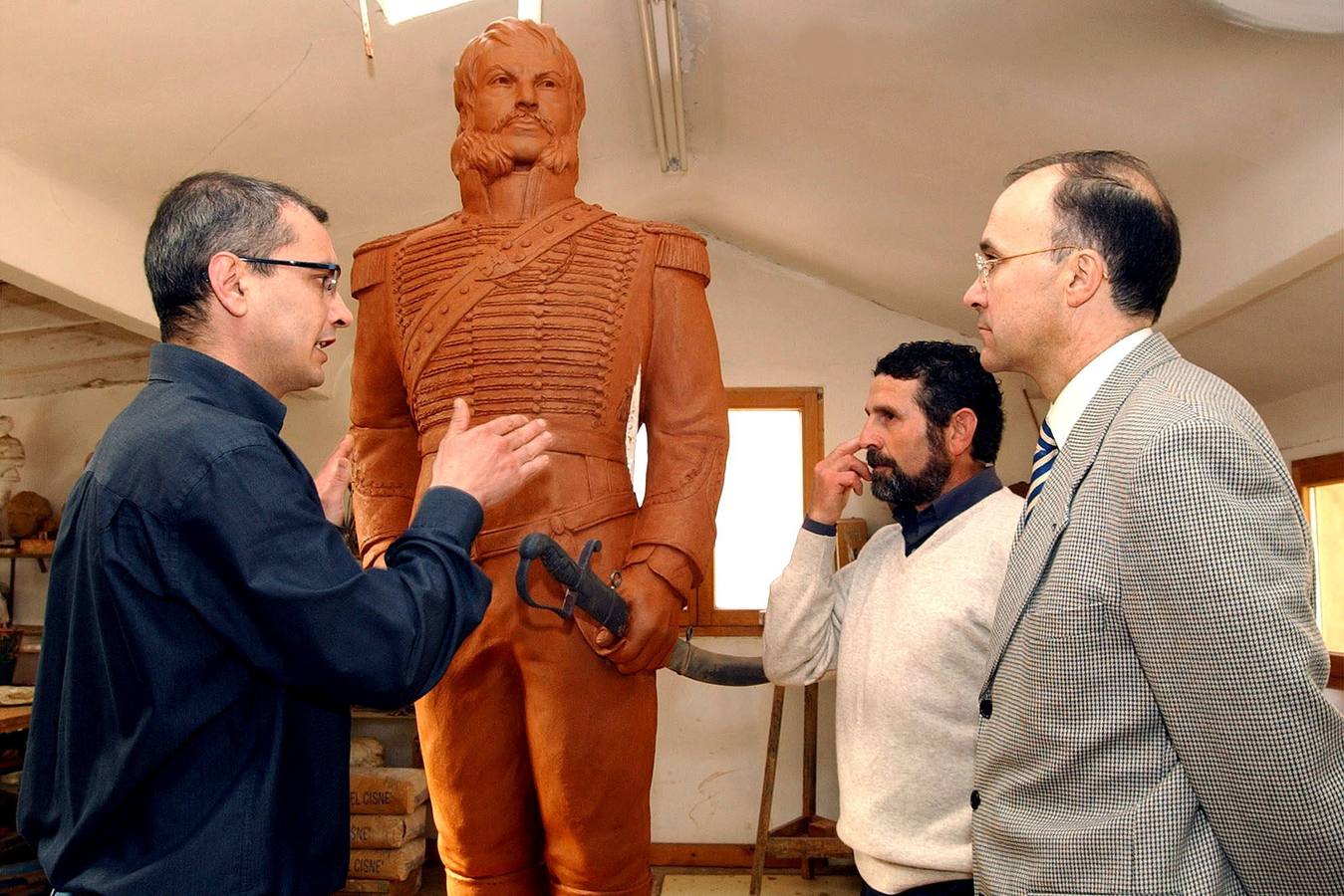 17.03.03 Ramiro Ruiz Medrano (d), y el alcalde de Castrillo de Duero, José María González (c), atienden a las explicaciones del escultor Luis Santiago sobre la escultura de la figura de Juan Martin Díaz 'El Empecinado', que se ubicará en la plaza de la localidad.