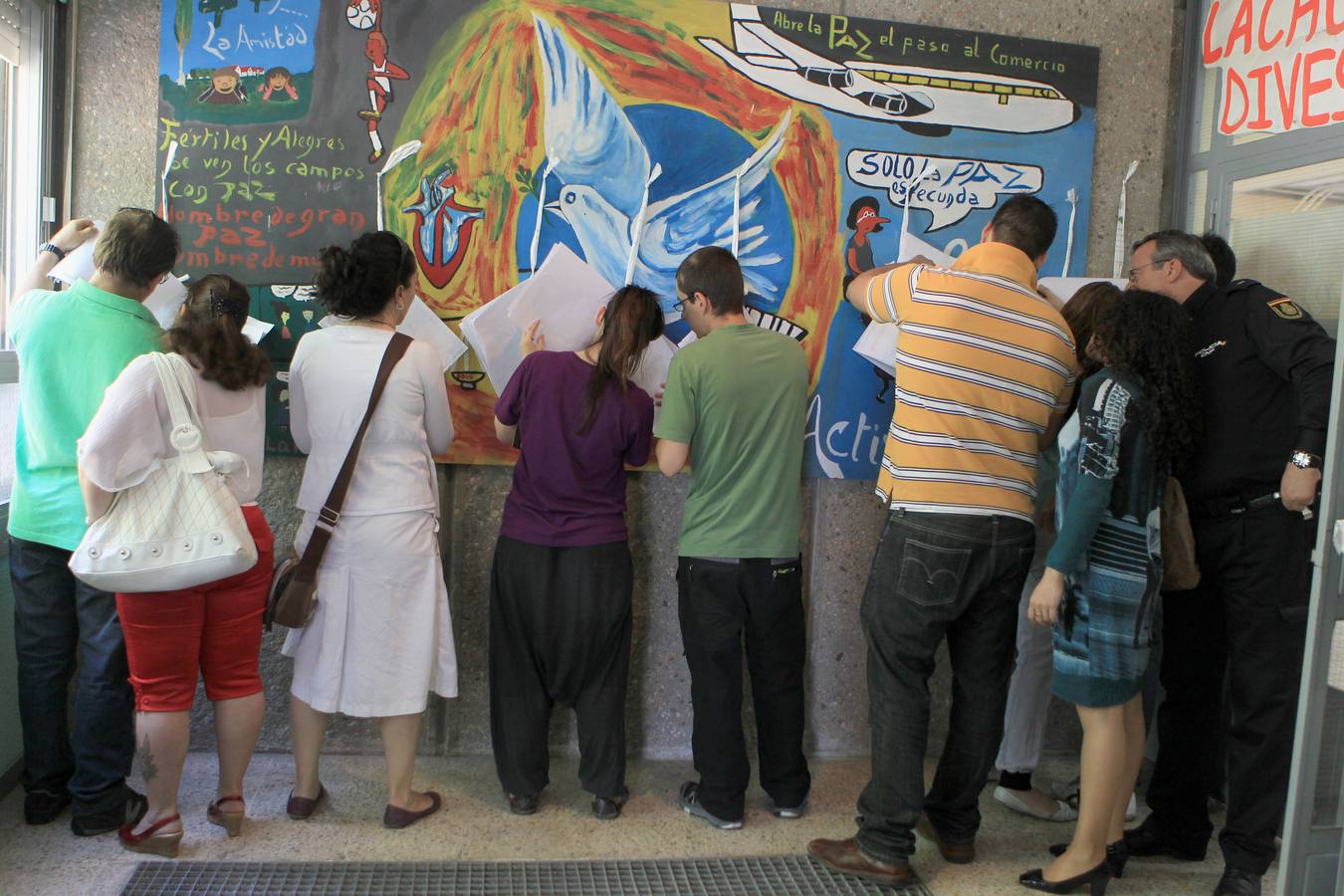 Varias personas miran las listas electorales en los Pajarillos.