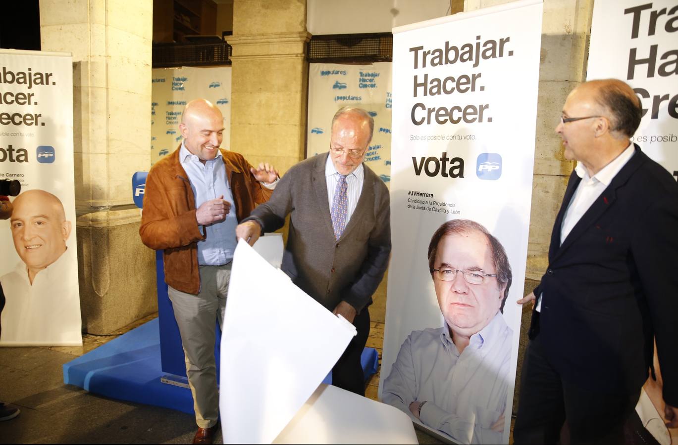 PP. Carnero, León de la Riva y Ruiz Medrano colocan carteles en la Plaza Mayor.