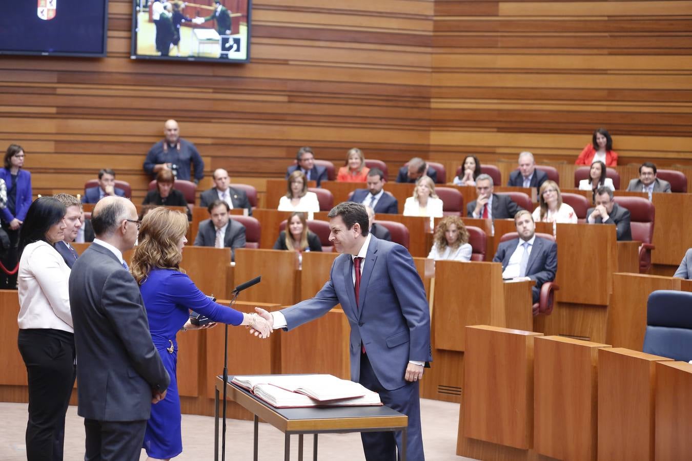 Carlos Fernández Carriedo, procurador del PP, saluda a la nueva presidenta tras jurar su cargo.