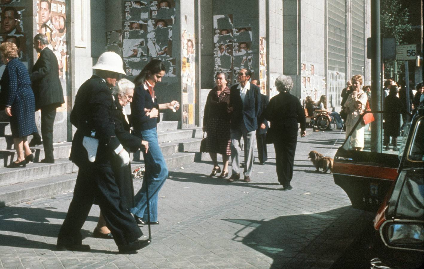15.06.1977 Un guardia municipal acomapaña a una anciana a la salida del colegio electoral de Madrid donde emitió su voto.
