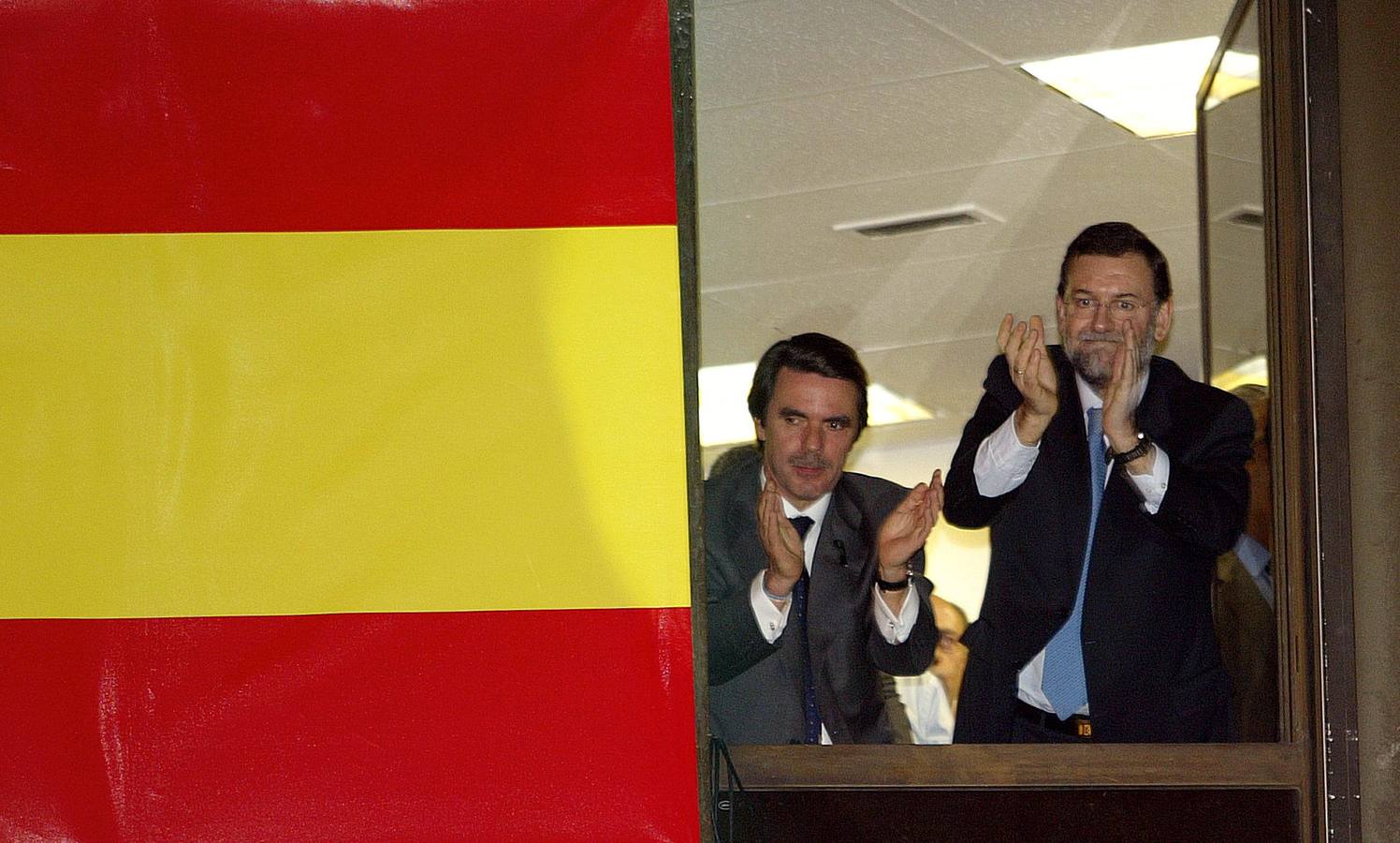 15.03.2004 El presidente, José María Aznar, y Mariano Rajoy, candidato por el PP a la presidencia del Gobierno español, aplauden el comportamiento de sus afiliados en la noche electoral.
