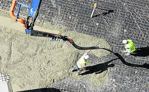 Una pareja de albañiles, durante la construcción de un edificio. 