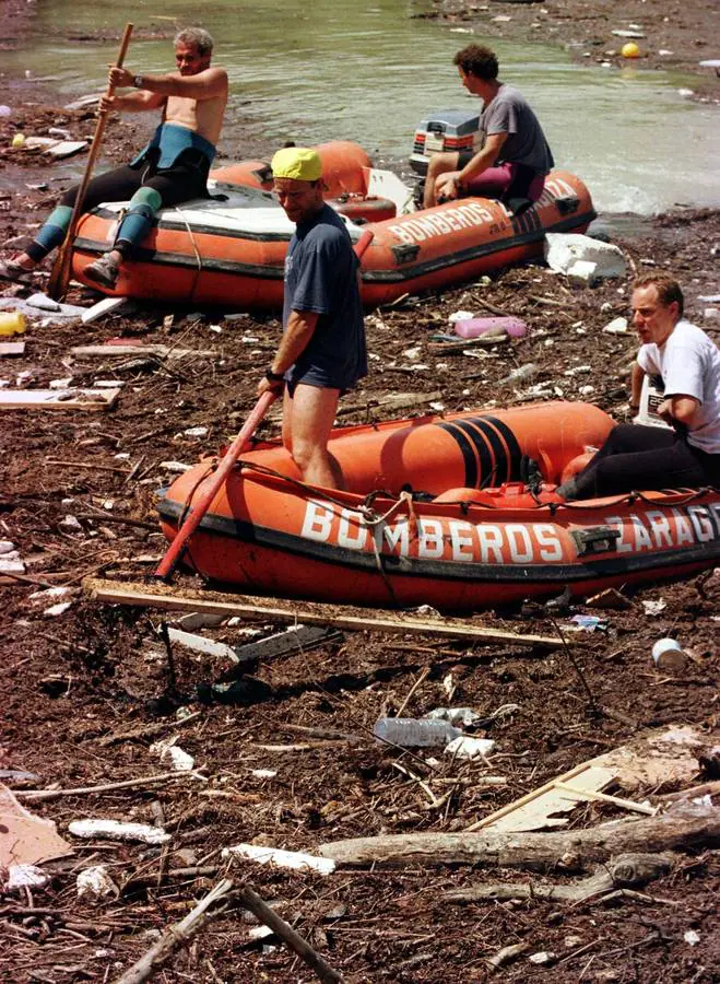 Personal realizando labores de rescate con lanchas zodiac entre los escombros y el barro.