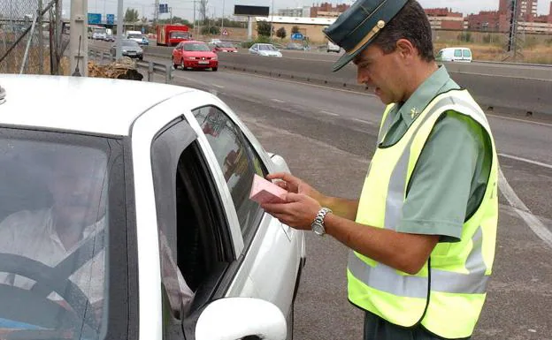 Un guardia civil observa el carnet de un conductor en un control de tráfico en Madrid