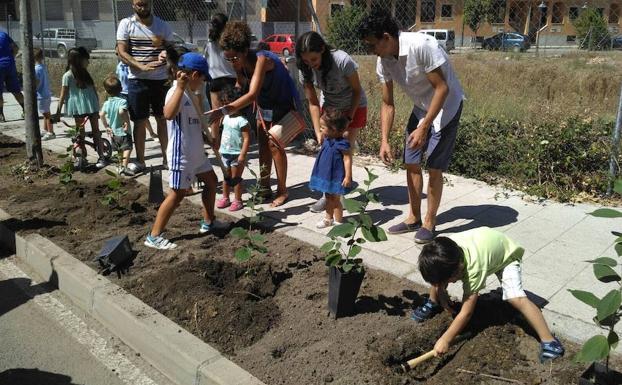 Niños y adultos participan en la actividad medioambiental. 