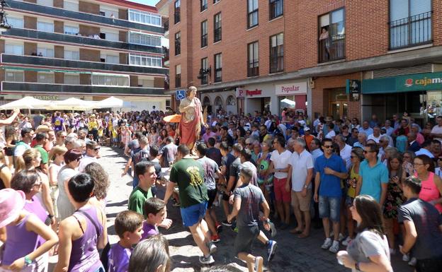 Los quintos portan la imagen de San Zoilo en andas por las calles del municipio.