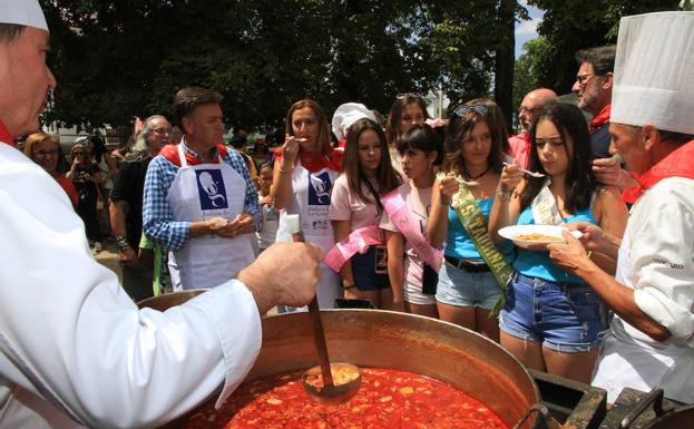 Las reinas de las fiestas de La Granja y representantes políticos prueban las alubias ofrecidas por los cocineros. 