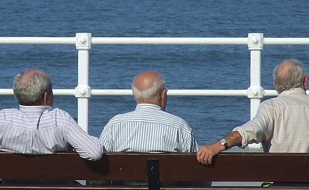 Tres hombre en el paseo marítimo de Gijón.