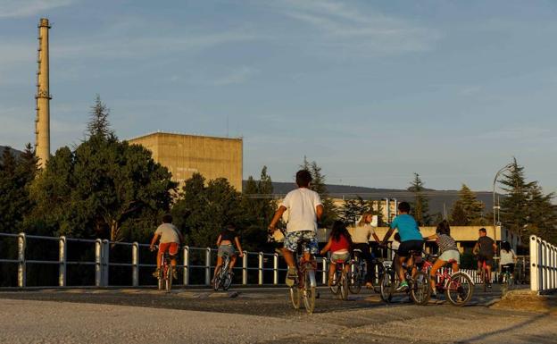 Niños juegan con las bicicletas cerca de la planta nuclear.