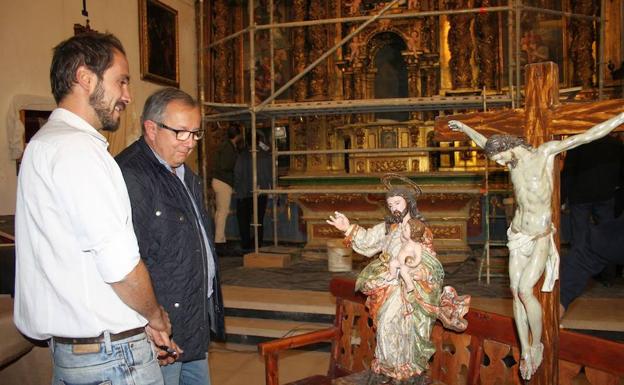 El delegado de la Junta y uno de los restauradores, con dos figuras de uno de los retablos. 