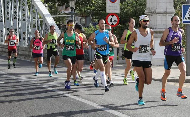 Grupo de corredores de la Media Maratón El Norte de Castilla a su paso por el Puente de Hierro.