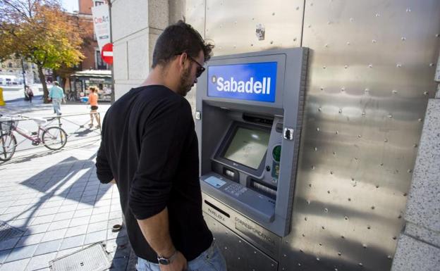 Un usuario delante de un cajero del Banco de Sabadell. 