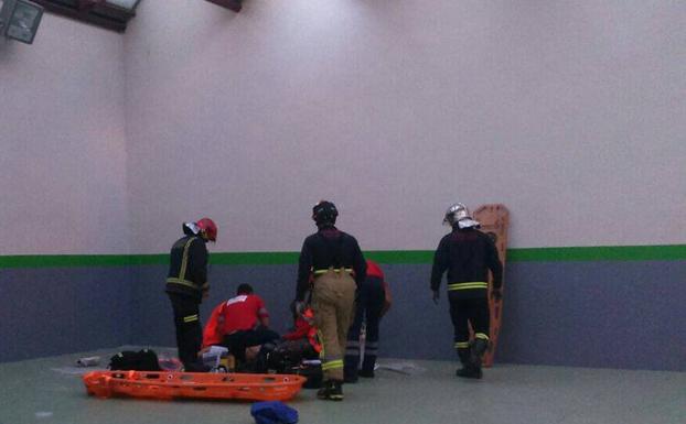 Sanitarios y bomberos atienden al joven herido.