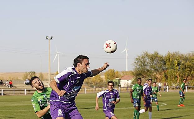 Melerocontrola de cabeza ante la presión del jugador del Atlético Astorga. 