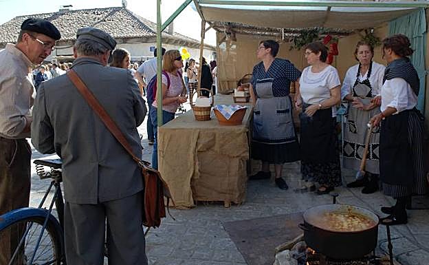 Varios asistentes, congregados en torno a uno de los puestos de la feria.