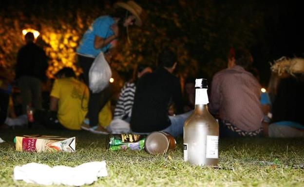 Restos de botellas y comida junto a grupos de jóvenes que participan del botellón.
