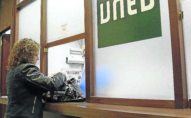 Una joven, en la secretaría de la UNED. 