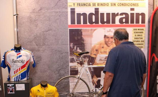 Un visitante de la exposición observa un cartel con la imagen de Indurain. 