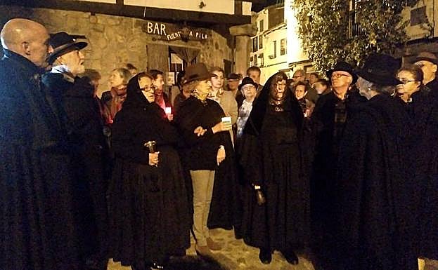 A la izquierda, una de las paradas del recorrido, en la que se ve en el centro de las dos mozas de ánimas con su esquila.