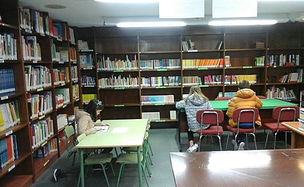 Varios niños leen en la biblioteca de Alba. 