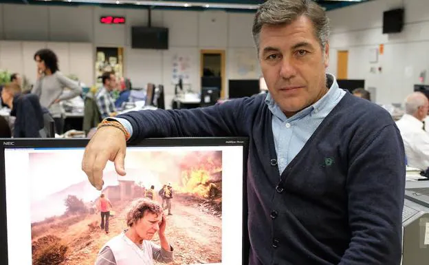 Gabriel Villamil posa con la imagen digital de la fotografía premiada sobre el incendio en La Cabrera, León. 